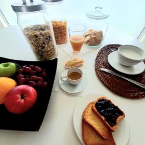 uma mesa com um prato de alimentos de pequeno-almoço e frutas em Gaia Suites em Turim