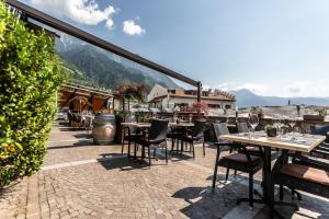 patio ze stołami i krzesłami na dachu w obiekcie Residence Kronenwirt w mieście Parcines