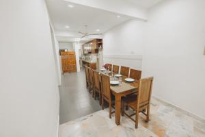 a dining room with a wooden table and chairs at PD Corner Lot 5R3BR 15pax Pool Homestay 5min to Beach in Port Dickson