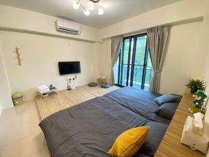 a bedroom with a large bed and a television at Pi-thon In House in Yujing