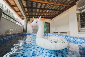 a pool with an inflatable unicorn in a swimming pool at PD Corner Lot 5R3BR 15pax Pool Homestay 5min to Beach in Port Dickson