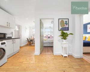 a kitchen and a living room with a table at Stunning Two Bed Apartment By PureStay Short Lets & Serviced Accommodation Leamington With Free WiFi in Leamington Spa