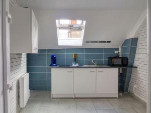 - une cuisine avec du carrelage bleu et un comptoir avec un évier dans l'établissement T2 proche du château de Blois, à Blois