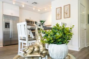 a vase with a giraffe sitting on a table with a plant at Modern 4BR Condo in the Heart of NOLA in New Orleans