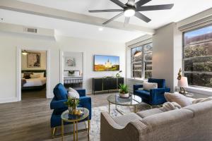 a living room with blue furniture and a ceiling fan at Modern 4BR Condo in the Heart of NOLA in New Orleans
