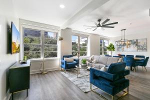 a living room with blue chairs and a couch at Modern 4BR Condo in the Heart of NOLA in New Orleans +38 photos