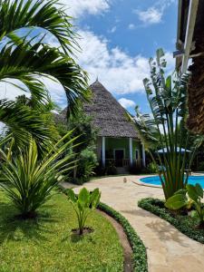 a resort with a swimming pool and palm trees at Paradiesische Villa Maisha Mazuri mit Pool. Terrasse und Personal in Diani Beach