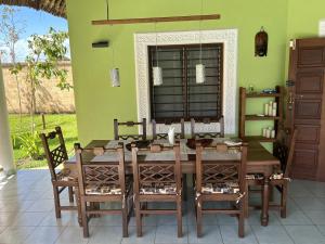 een eetkamer met een houten tafel en stoelen bij Paradiesische Villa Maisha Mazuri mit Pool. Terrasse und Personal in Diani Beach