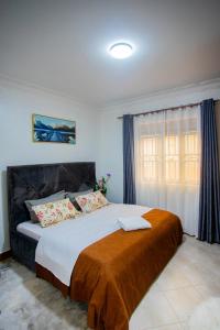 ein Schlafzimmer mit einem großen Bett mit einer braunen Decke in der Unterkunft MANDJ STAYS in Seeta