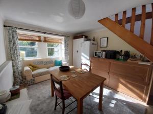 a kitchen and living room with a table and a couch at Idyllic cottage in peaceful rural location in Helensburgh