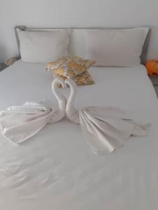zwei Schwäne auf einem weißen Bett mit Handtüchern in der Unterkunft Casandra in Mamaia Nord – Năvodari
