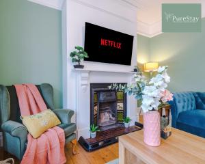 a living room with a tv above a fireplace at Incredible Five Bedroom House By PureStay Short Lets & Serviced Accommodation Central Bath With Parking in Bath