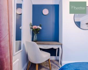 a room with a table with a chair and a vase of flowers at Incredible Five Bedroom House By PureStay Short Lets & Serviced Accommodation Central Bath With Parking in Bath