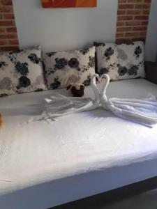zwei weiße Schwäne auf einem Bett mit Kissen in der Unterkunft Casandra in Mamaia Nord – Năvodari