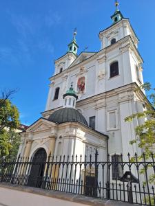a tall white building with a fence in front of it at Apartment with Entresol Old Town Krakow in Krakow