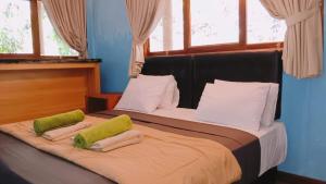 - une chambre avec 2 lits dotés d'oreillers verts et blancs dans l'établissement CELUK VILLA, à Amed