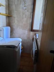 a small bathroom with a toilet and a sink at Mansarda Carona in Carona +2 photos