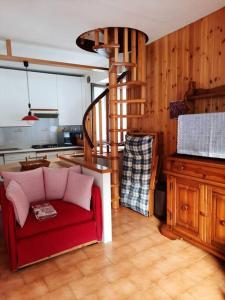 a living room with a red couch in a kitchen at Mansarda Carona in Carona