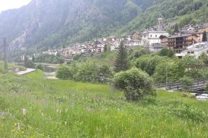 a green hillside with a village in the distance at Mansarda Carona in Carona +9 photos