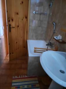 a bathroom with a sink and a tub and a toilet at Mansarda Carona in Carona