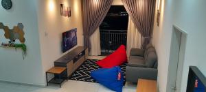 a living room with a couch and red and blue pillows at D'Homestay Adelia Residence Bangi Avenue in Kajang