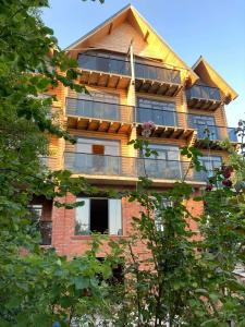 a tall brick building with a balcony on it at Hotel ANNA PALACE in Khulo