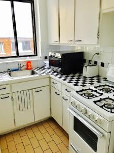 a kitchen with white cabinets and a stove top oven at Stylish Montreal Apartment: Comfortable Stay in the Golden Square Mile in Montreal