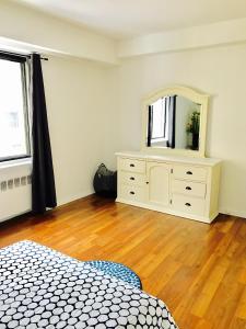 a bedroom with a dresser and a mirror in it at Stylish Montreal Apartment: Comfortable Stay in the Golden Square Mile in Montreal