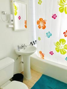 łazienka z umywalką i zasłoną prysznicową w obiekcie Stylish Montreal Apartment: Comfortable Stay in the Golden Square Mile w Montrealu