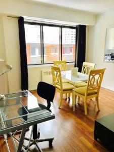 d'un salon avec une table, des chaises et une fenêtre. dans l'établissement Stylish Montreal Apartment: Comfortable Stay in the Golden Square Mile, à Montréal