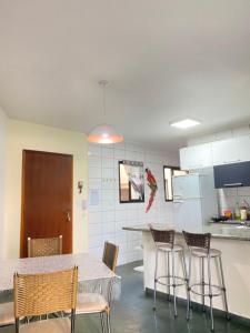 a kitchen with a table and chairs and a counter at APARTAMENTO EM BERTIOGA in Bertioga