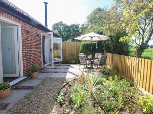 Un patio con una sombrilla y una mesa y sillas. en Beck View, en Norwich
