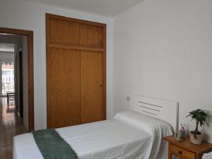 トレビエハにあるAtico en calle concordia, cerca Playa del Curaのベッドルーム1室(ベッド2台付)、木製のドアが備わります。