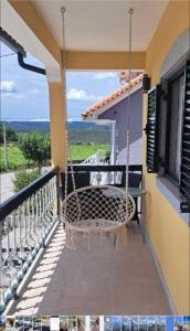 a porch with a swing on a house at Casa De Ferias Santos in Aguiar da Beira