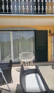 a porch with a swing and a table and chairs at Casa De Ferias Santos in Aguiar da Beira