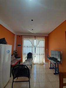 un soggiorno con pareti e sedie arancioni e TV di str_on 4 a Encarnación