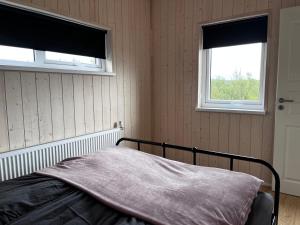 sypialnia z łóżkiem i dwoma oknami w obiekcie Ásólfsstaðir - Miðhóll w mieście Ásólfsstaðir