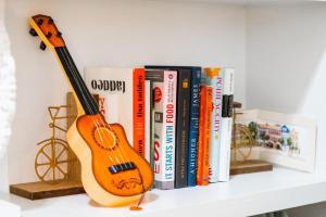 a book shelf with a guitar and books at Boho SoCo- 8 mins to Credit One 20 mins to DTWN in Charleston