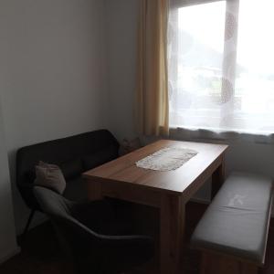 una mesa y una silla en una habitación con ventana en Ferienwohnung Weiss, en Waidring