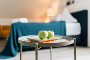 two green apples on a plate on a table at Stadt-Appartement CityLife in Bielefeld