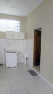 a white bathroom with a sink and a toilet at Suíte para Hospedagem em Porto Belo in Porto Belo