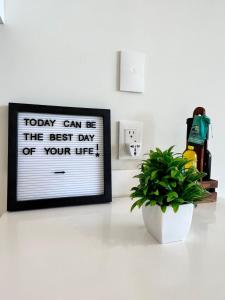 a sign on a counter with a plant and a picture at Moderno y espacioso departamento en Aldea Zama in Tulum