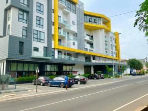 阿克拉的住宿－Labone Luxury Condo and Apartment in Accra - FiveHills homes，停车场内停放汽车的大型建筑