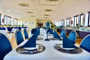 a long table with blue chairs and plates and glasses at Jess Hotel Krolewski Gdansk Old Town in Gdańsk