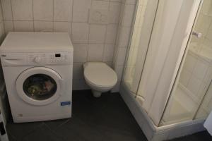 a small bathroom with a washing machine and a toilet at Stay2Night City Center Hostel in Zurich