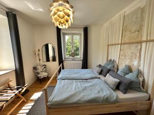 um quarto com uma cama e um lustre em Villa Anton em Murnau am Staffelsee
