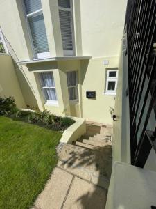 una casa con escaleras que conducen a la puerta principal en Garden flat in 'Little Chelsea', en Eastbourne