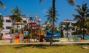 a playground in a park with palm trees at Njakaimba Beachfront Villa. in Mombasa