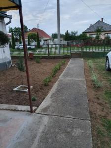 un trottoir dans une cour à côté d'une clôture dans l'établissement House Lorien, à Nyírbogdány