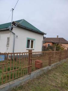 une maison blanche derrière une clôture en bois dans l'établissement House Lorien, à Nyírbogdány